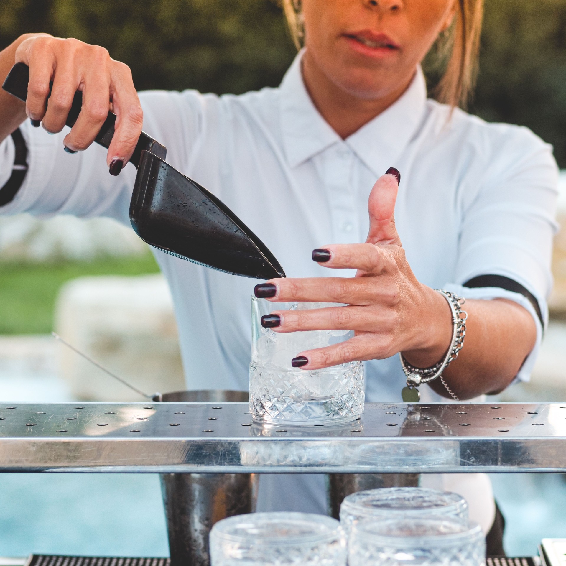 Closeup of the barmaid making a cold cocktail.